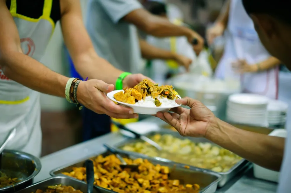 volunteers serving a healthy meal to people in need